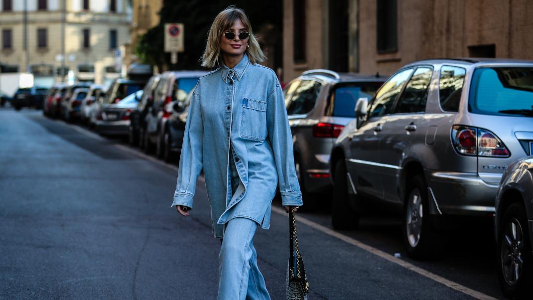 γυναίκα περπατά με τζιν πουκάμισο και παντελόνι στην εβδομάδα μόδας