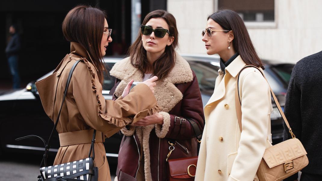 γυναίκες συζητούν στο δρόμο με παλτό και γυαλιά