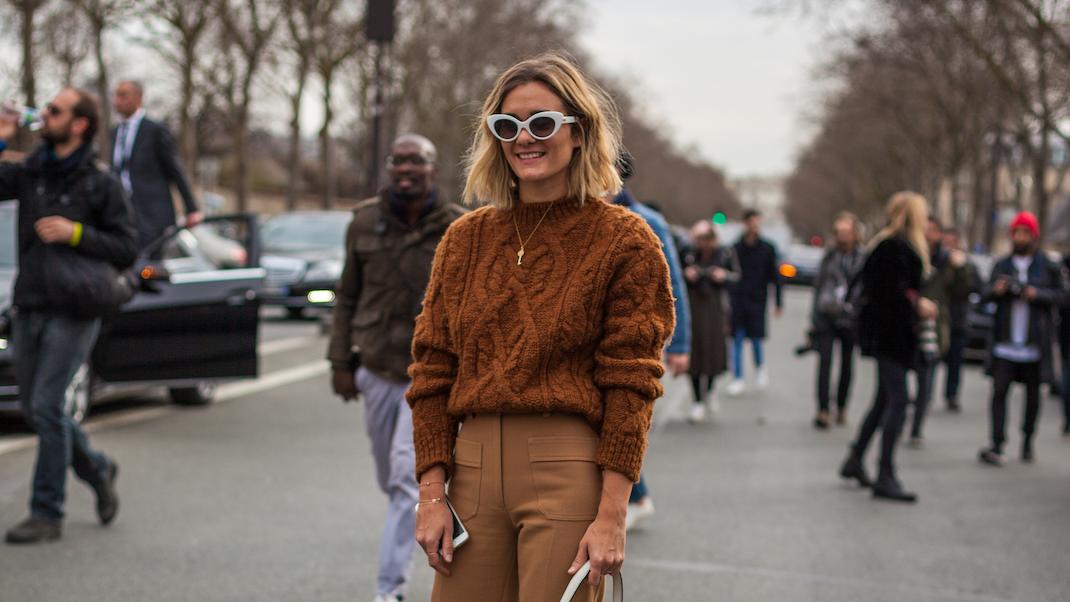 γυναίκα με καφέ πουλόβερ και γυαλιά στην εβδομάδα μόδας