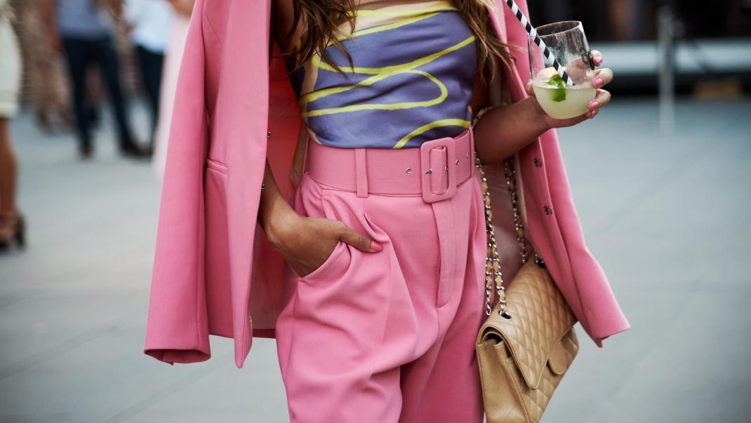 Γυναίκα με ροζ κοστούμι και ποτό στο χέρι 