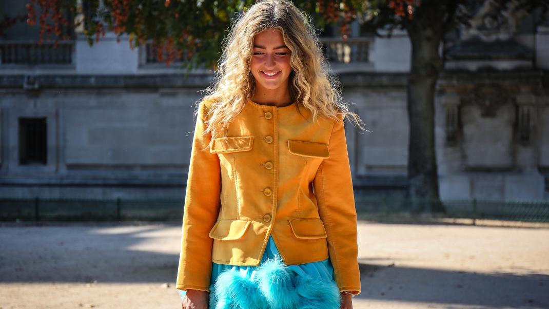 γυναίκα με κίτρινο σακάκι περπατά στην εβδομάδα μόδας