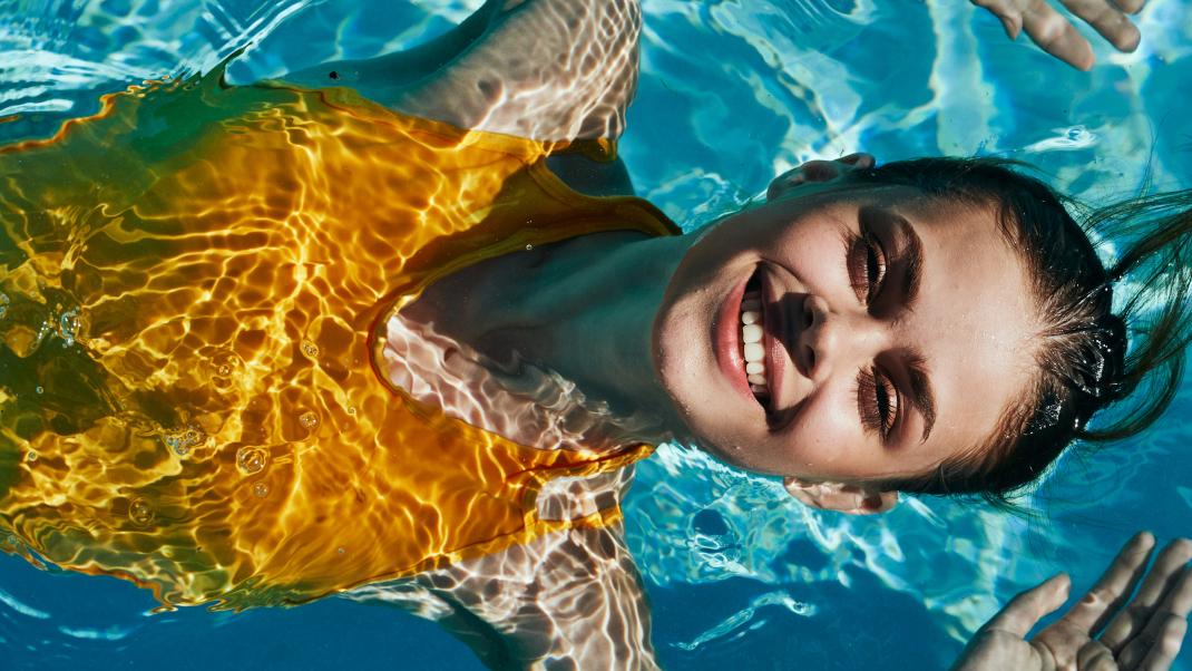 Γυναίκα με κίτρινο μαγιό στην πισίνα