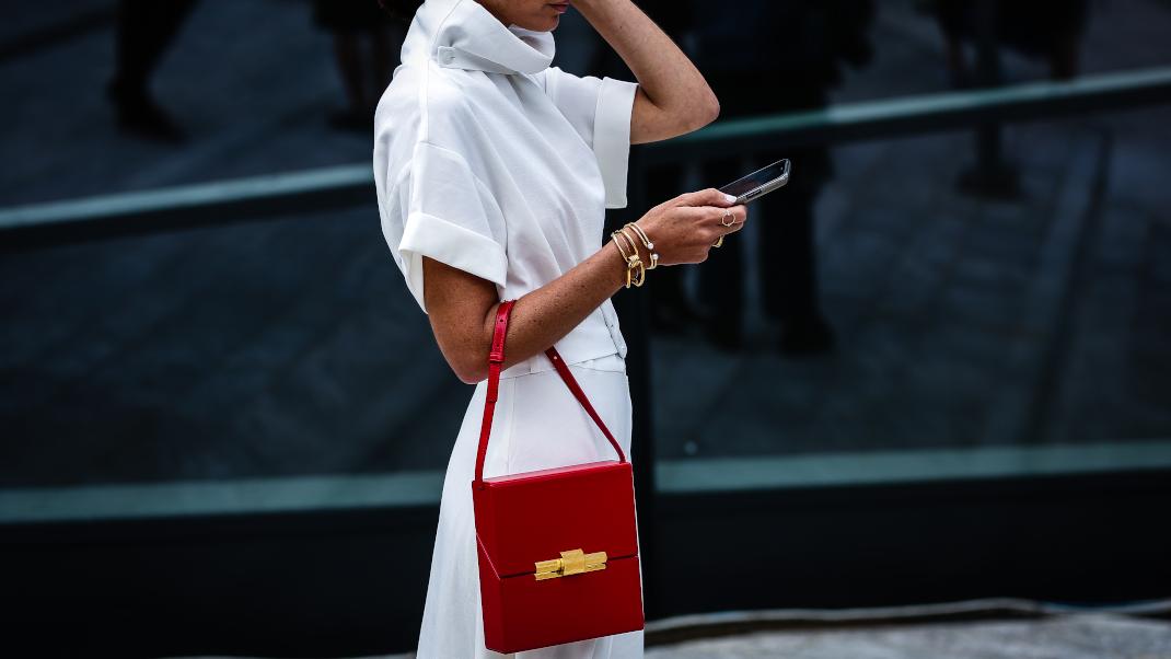 γυναίκα με λευκό φόρεμα και τσάντα στην εβδομάδα μόδας