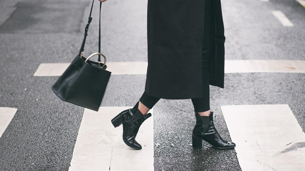 Στιλάτη γυναίκα με δερμάτινες μπότες και τσάντα
