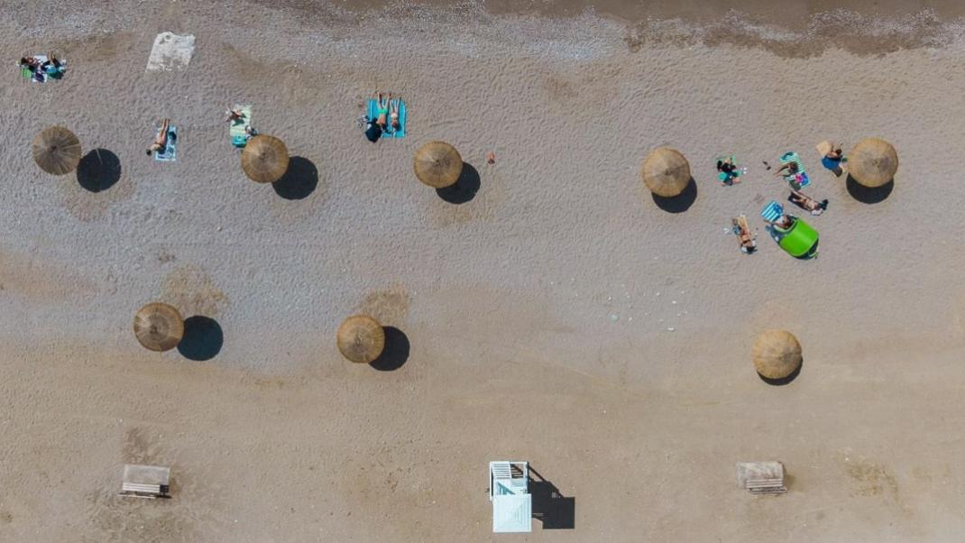 Καινούργιες ομπρέλες και φρέσκια άμμο στην παραλία της Γλυφάδας 