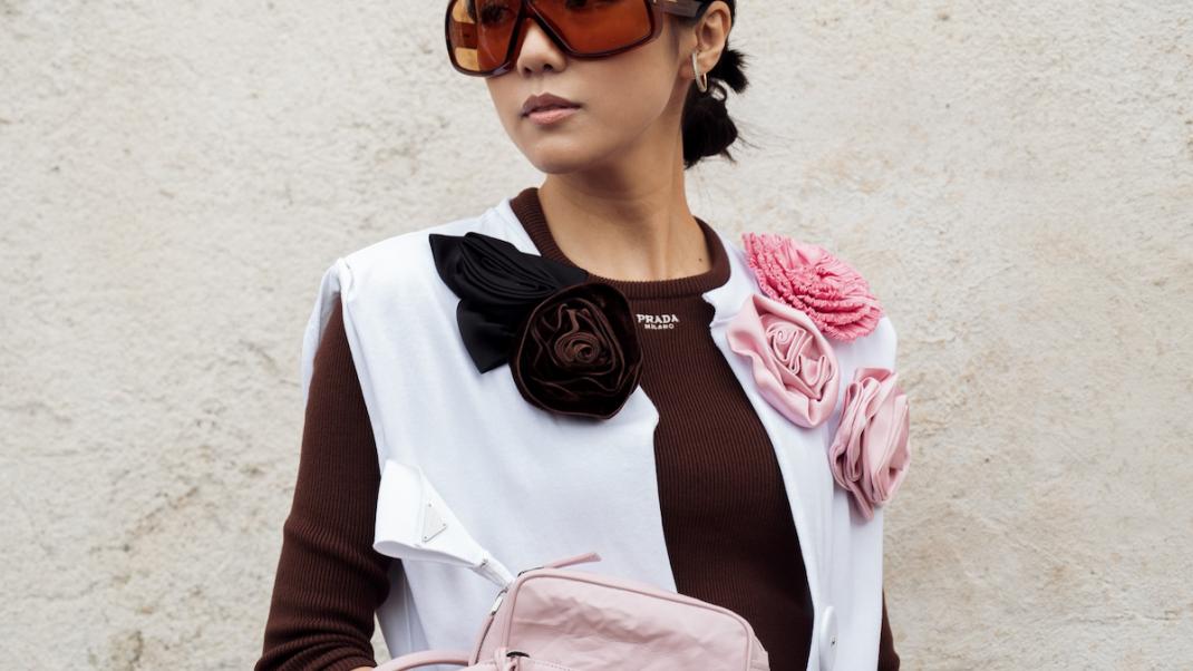 γυναίκα με τοπ με λουλούδια και γυαλιά στην εβδομάδα μόδας