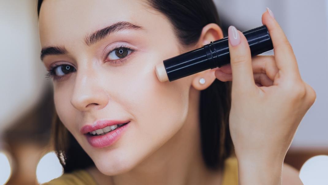 Γυναίκα εφαρμόζει concealer/Shutterstock