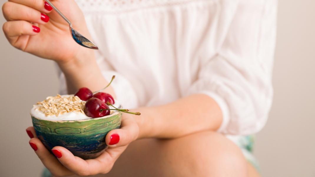 Γυναίκα τρώει γιαούρτι με κεράσια, Φωτογραφία: Shutterstock
