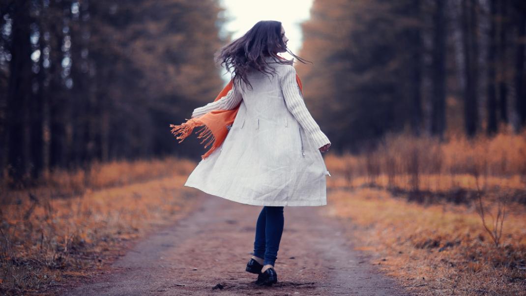 Μια γυναίκα περπατάει χαρούμενη στο πάρκο, Φωτογραφία: Shutterstock