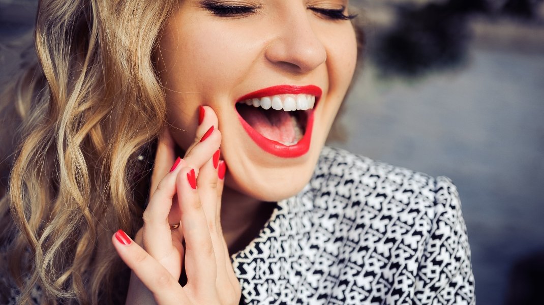 Γυναίκα με κόκκινα νύχια και χείλη/Shutterstock