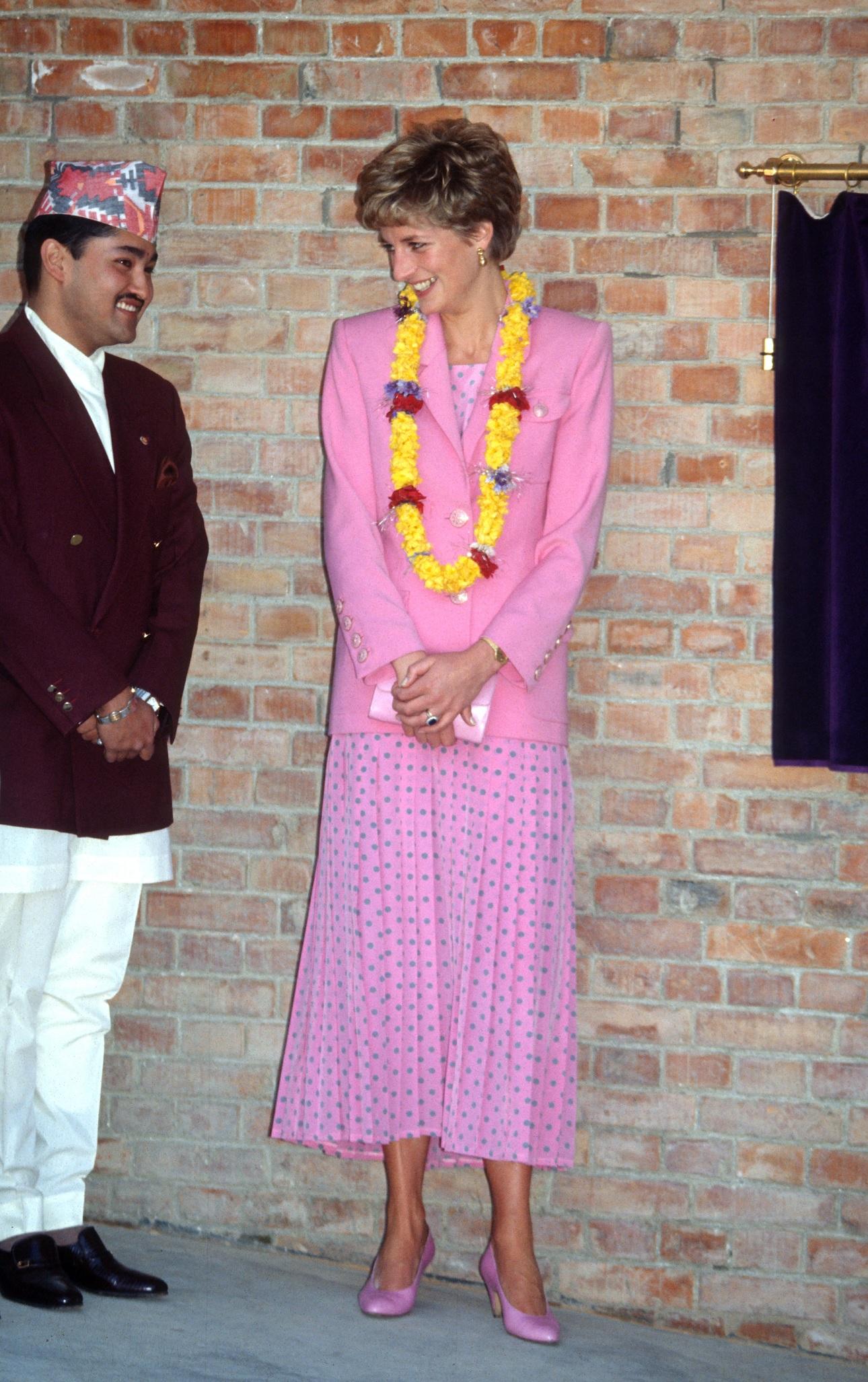 Η Νταϊάνα φορώντας ένα ροζ φόρεμα με μπλε πουά και ένα ροζ σακάκι από τον Πολ Κοστέλο