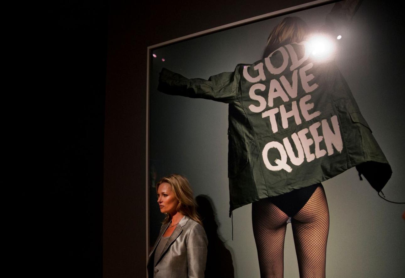 Η Κέιτ Μος ποζάρει δίπλα σε μια φωτογραφία της για το περιοδικό i-D από τον Craig McDean στον οίκο δημοπρασιών Christie's στο Λονδίνο, την Τετάρτη 4 Σεπτεμβρίου 2013/Φωτογραφία: AP Photo/Matt Dunham