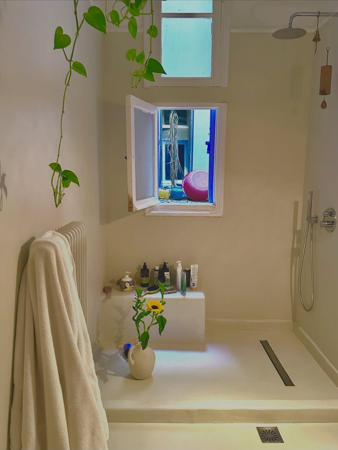 Το walk-in ντους και η μίνιμαλ αισθητική δημιουργούν μια ήρεμη και φωτεινή ατμόσφαιρα στο μπάνιο.