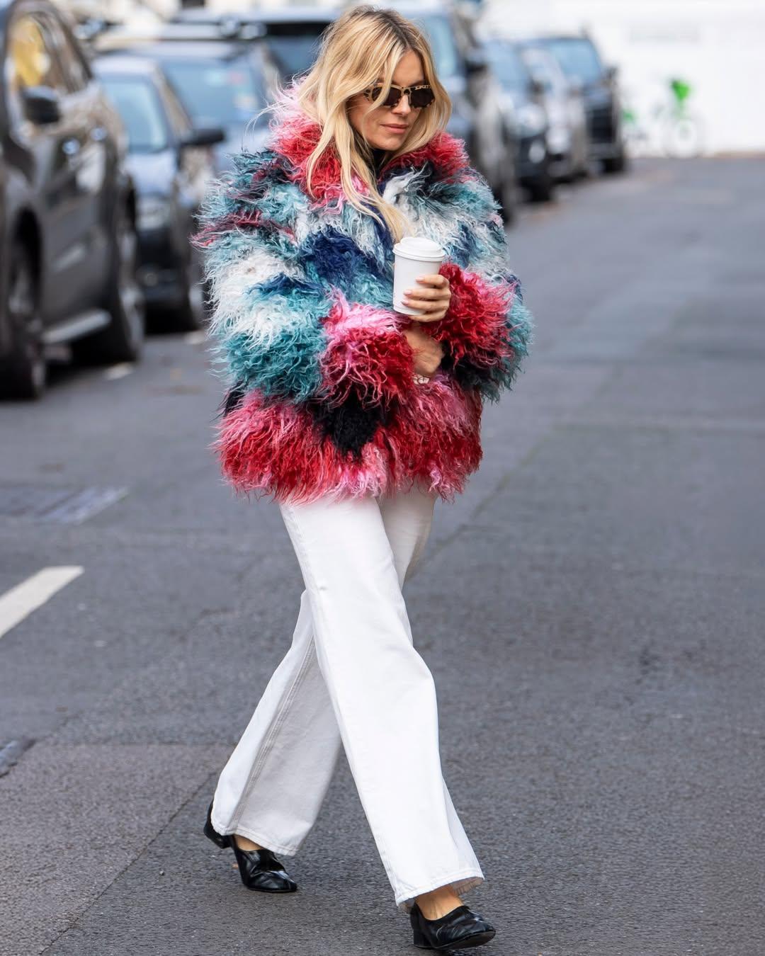 Η Σιένα Μίλερ συνδύασε το πολύχρωμο Desigual παλτό με λευκό παντελόνι/ Φωτογραφία: Instagram/ @desigual 