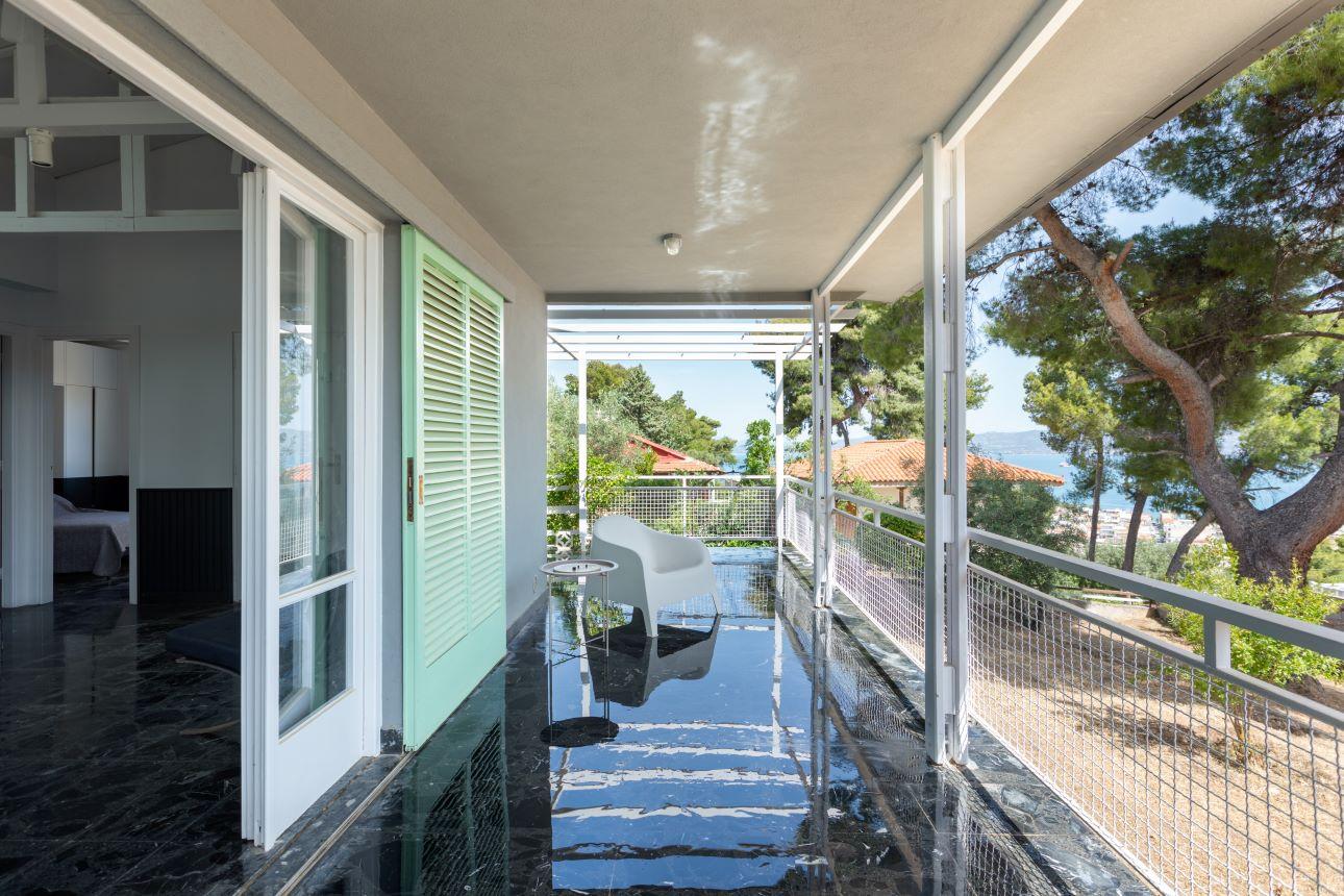 Η σκιερή βεράντα λειτουργεί ως φυσική συνέχεια του εσωτερικού χώρου/ Φωτογραφία: Μαριάνα Μπίστη  
