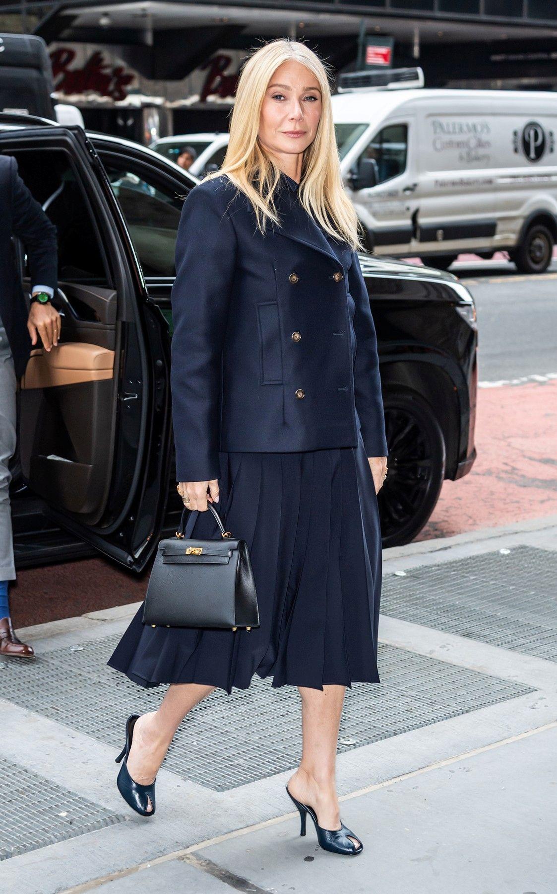 Το απόλυτο business look: Η Γκουίνεθ Πάλτροου με σκούρο μπλε σακάκι με χρυσά κουμπιά, πλισέ φούστα, peep-toe mules και τσάντα Hermès σε ταιριαστό χρώμα. 