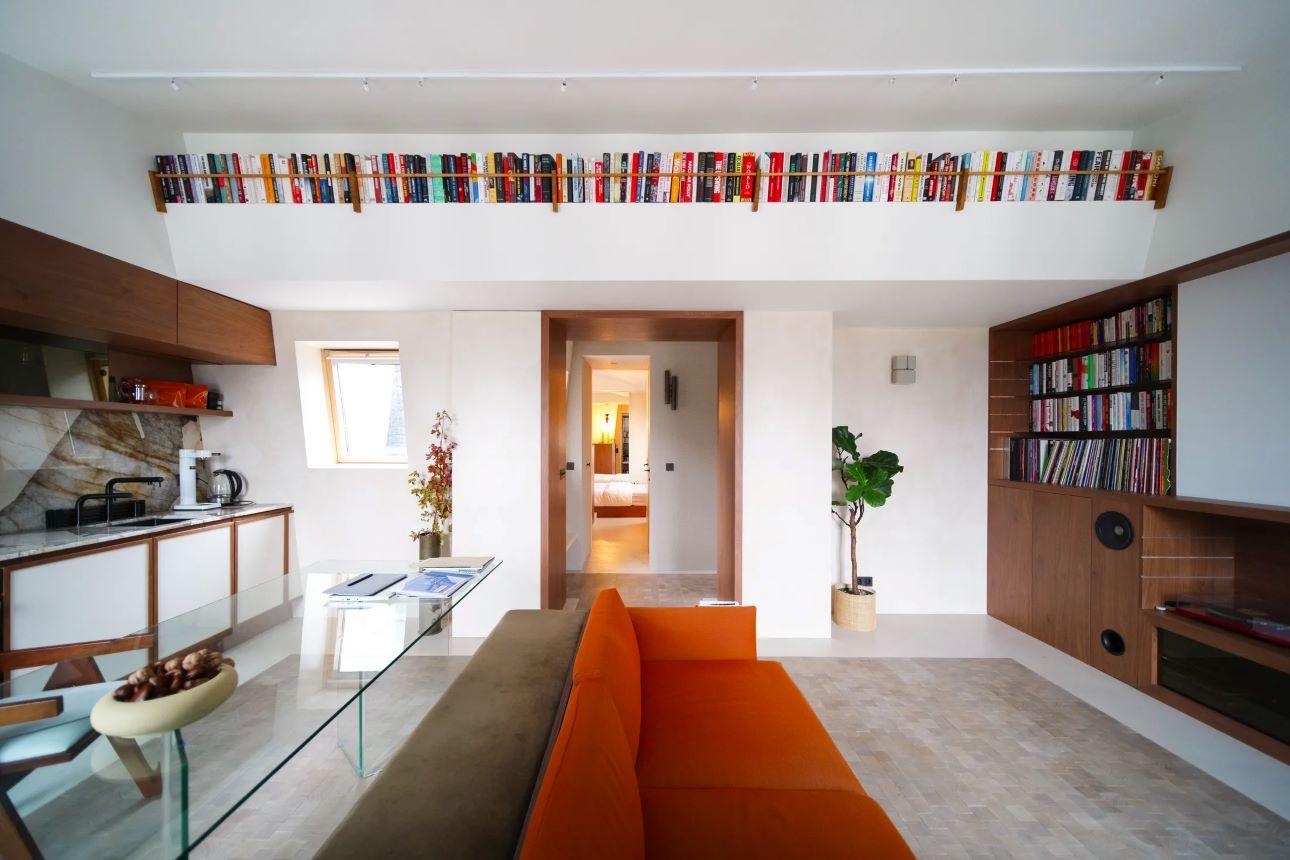 Ξεχωρίζει το ειδικά σχεδιασμένο έπιπλο πίσω από τον καναπέ που ενσωματώνει αποθηκευτικούς χώρους και επεκτείνεται ως ενιαίο παγκάκι/ Φωτογραφία: Viviane Chil-Hagopian