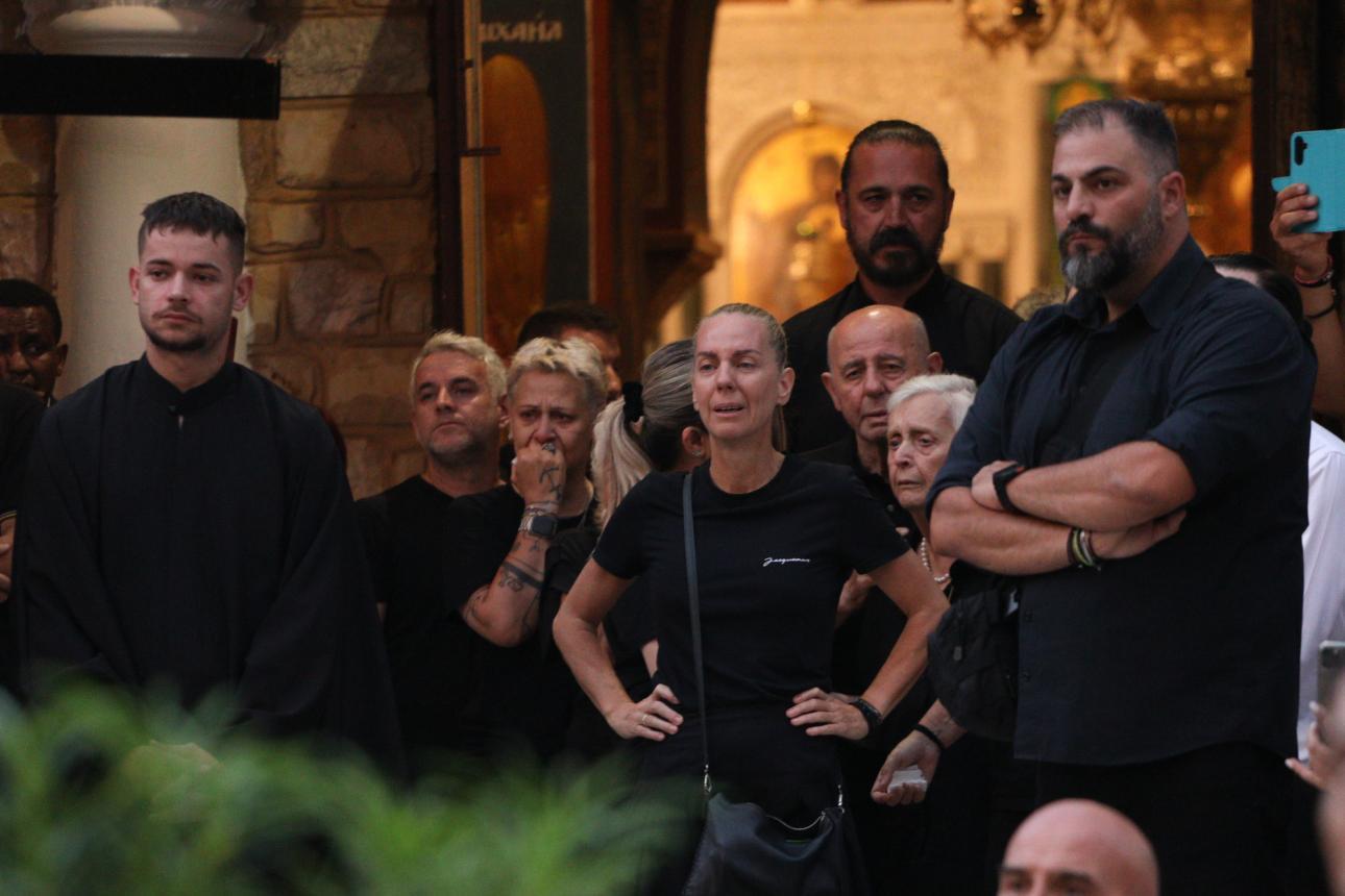 Ο Δημήτρης Μακρυνιώτης, σύντροφος της Βάσως Μαζωνάκη, διακρίνεται πίσω από τον πατέρα της οικογένειας, Μανώλη Μαζωνάκη, κατά τη διάρκεια της αγρυπνίας. /Φωτογραφία: Ιntime News