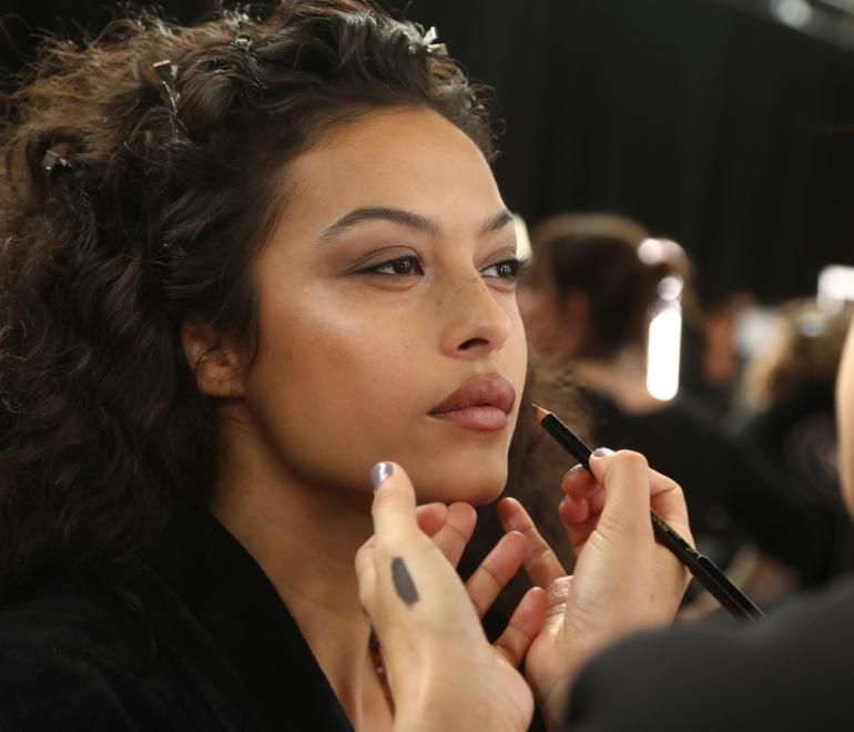 Μοντέλο που βάζει καφέ μολύβι στα χείλη της