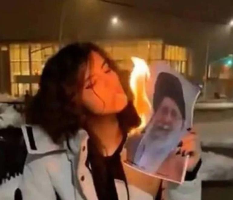 Η γυναίκα που ανάβει τσιγάρο με φωτογραφία Ιρανού ηγέτη