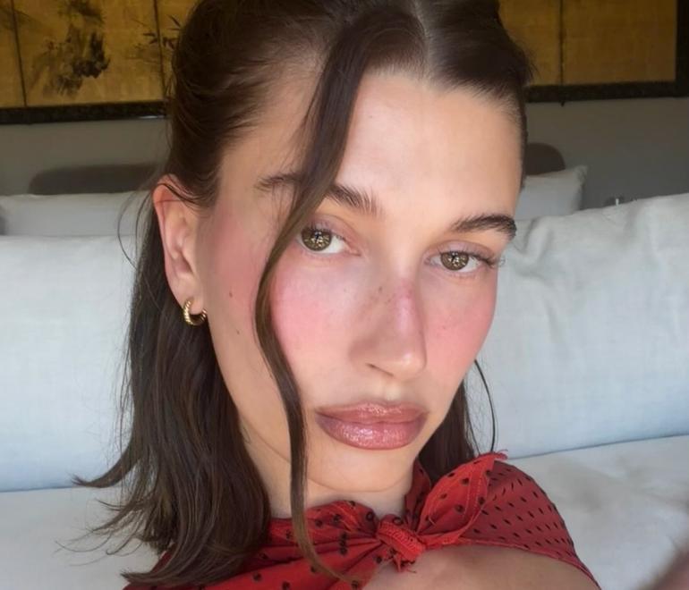 Η Χέιλι Μπίμπερ με κόκκινο πουά φόρεμα και ροζ ρουζ