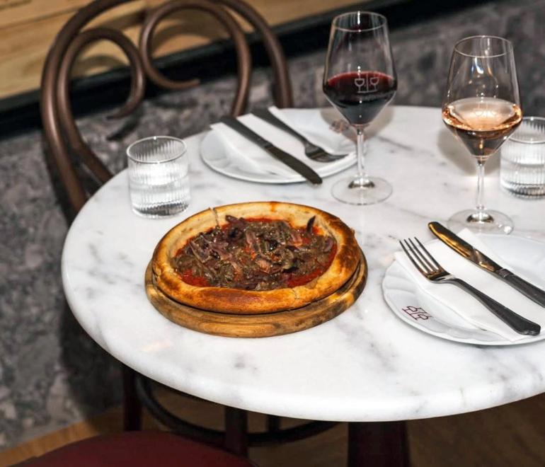 Πίτσα και ποτήρια στο τραπέζι