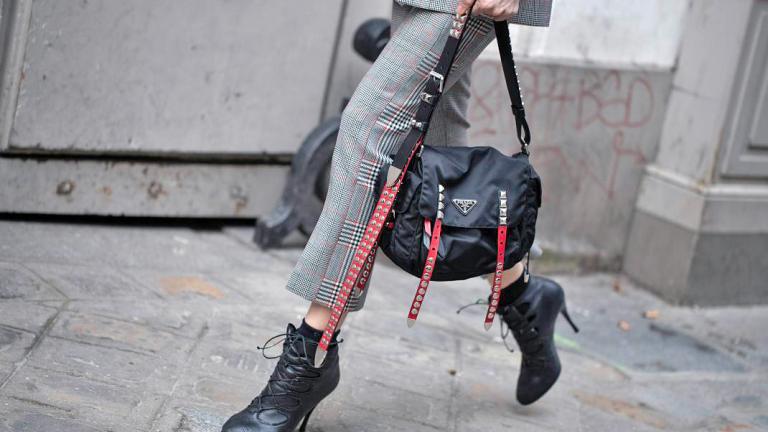 Γυναίκα με καρό σύνολο, μαύρα ankle boots, μαύρη τσάντα