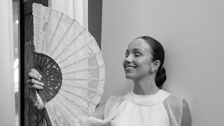 Η νύφη ποζάρει στον φακό κάνοντας αέρα με βεντάλια