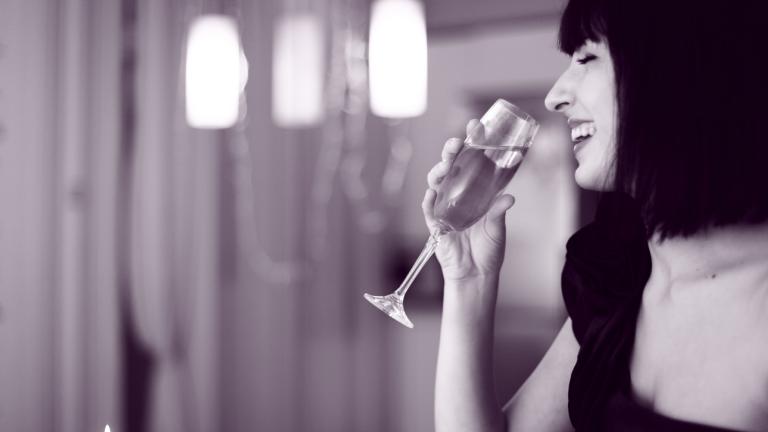 Χαμογελαστή γυναίκα πίνει σαμπάνια 