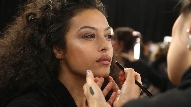 Μοντέλο που βάζει καφέ μολύβι στα χείλη της