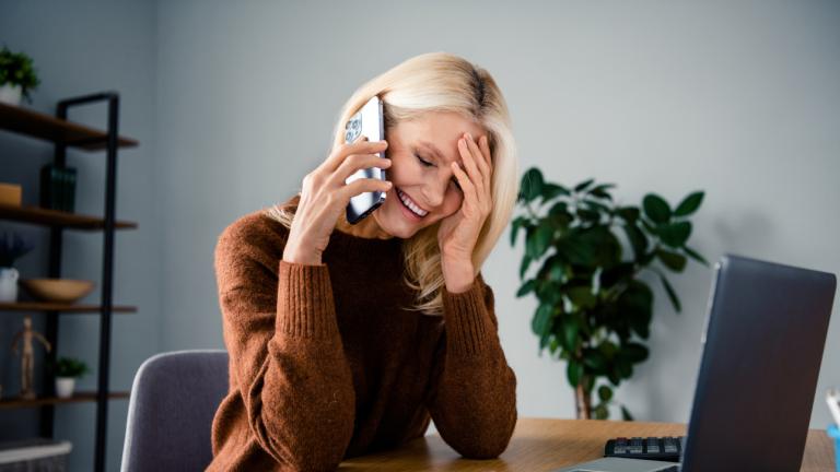 Γυναίκα που μιλάει στο τηλέφωνο και πιάνει τα μαλλιά της