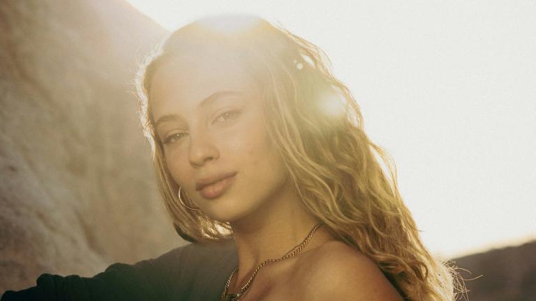 νεαρή γυναίκα με μακριά ξανθά μαλλιά κάτω από τον ήλιο