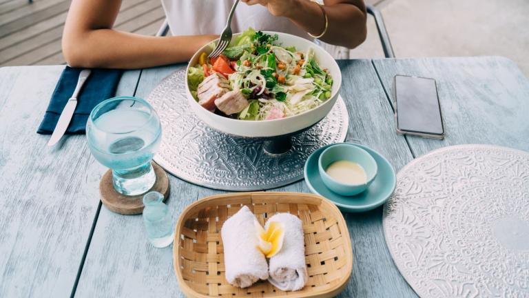 γυναίκα έχει νερό με το φαγητό στο τραπέζι