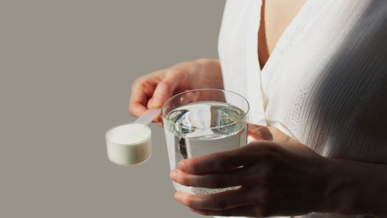 γυναίκα κρατάει συμπληρώματα διατροφής με κολλαγόνο ή πρωτόγαλα