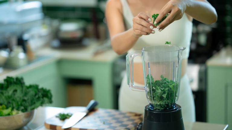 γυναίκα ετοιμάζει smoothie με kale για αδυνάτισμα και καλύτερο μεταβολισμό