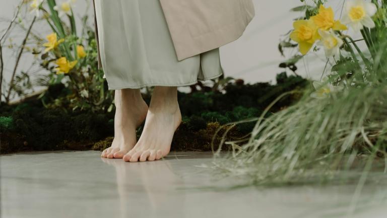 πόδια χωρίς παπούτσια σε φόντο με λουλούδια