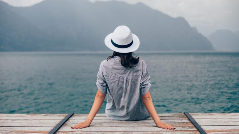 Γυναίκα φοράει καπέλο και αγναντεύει τη θάλασσα, Φωτογραφία: Shutterstock/By Viktor Gladkov