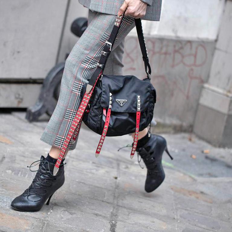 Γυναίκα με καρό σύνολο, μαύρα ankle boots, μαύρη τσάντα