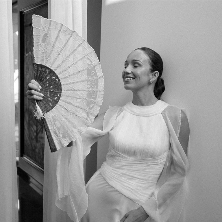 Η νύφη ποζάρει στον φακό κάνοντας αέρα με βεντάλια