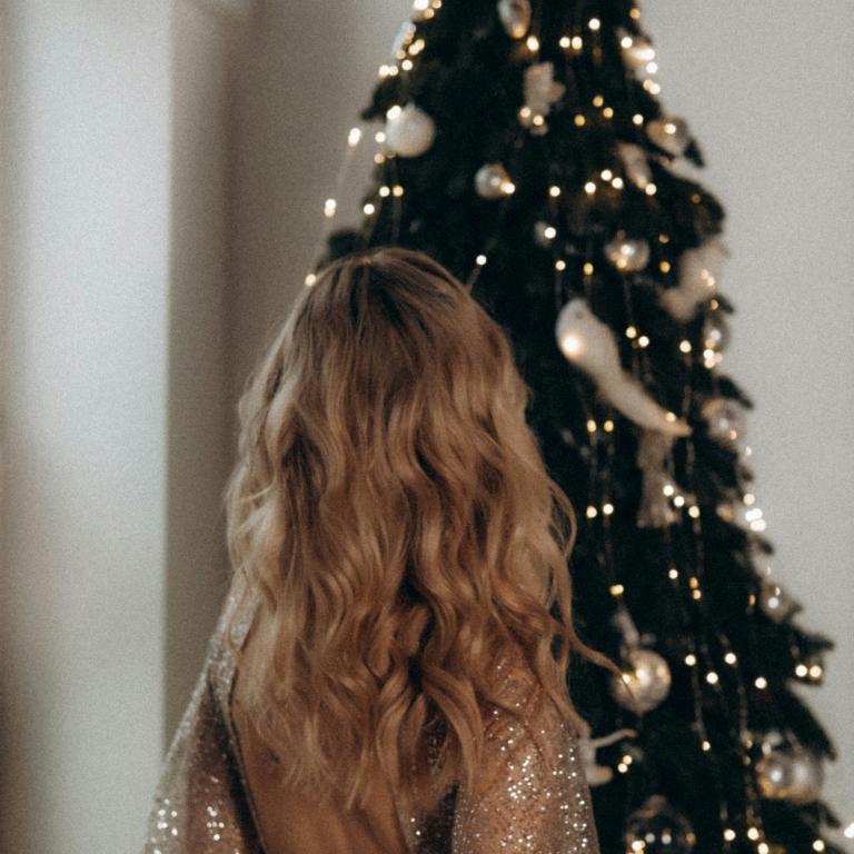 Γυναίκα στέκεται μπροστά από χριστουγεννιάτικο δέντρο