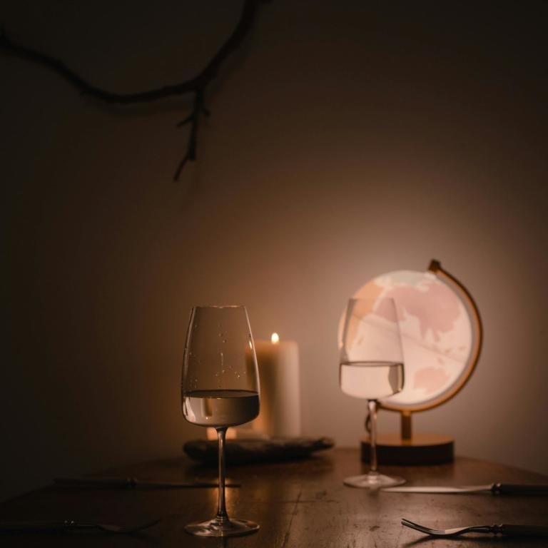 Τραπέζι με ποτήρι κρασί και ένα αναμμένο κερί