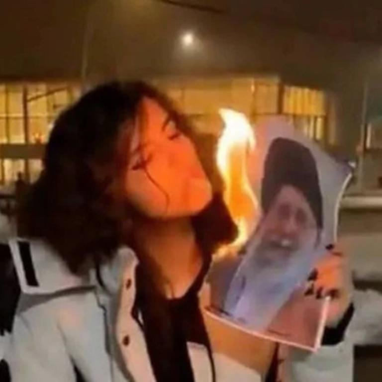 Η γυναίκα που ανάβει τσιγάρο με φωτογραφία Ιρανού ηγέτη