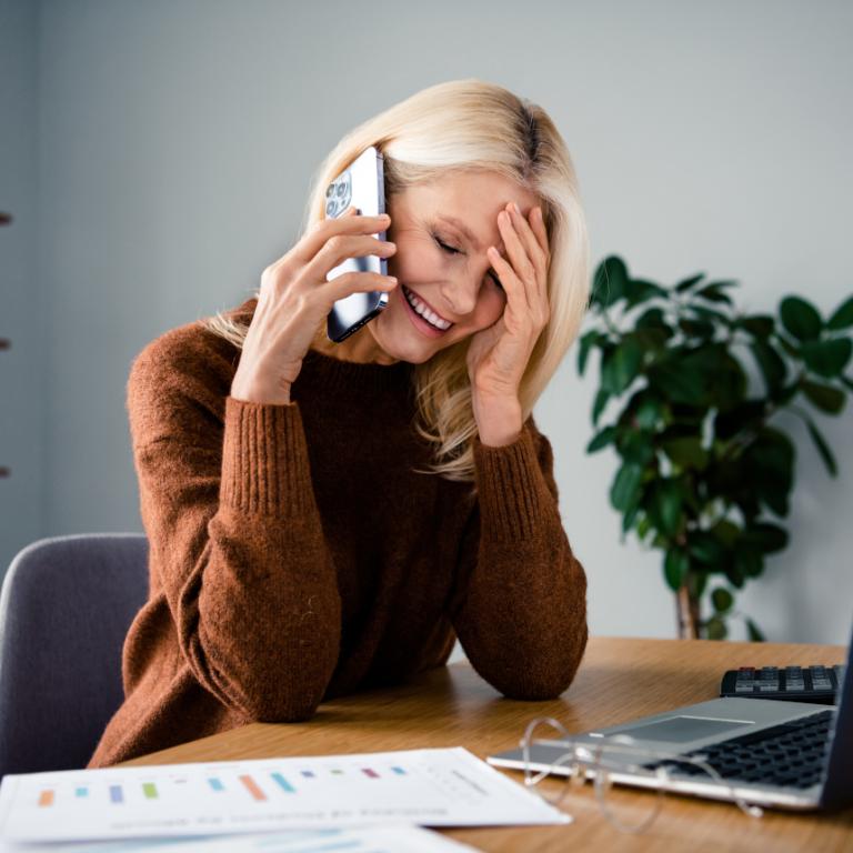 Γυναίκα που μιλάει στο τηλέφωνο και πιάνει τα μαλλιά της