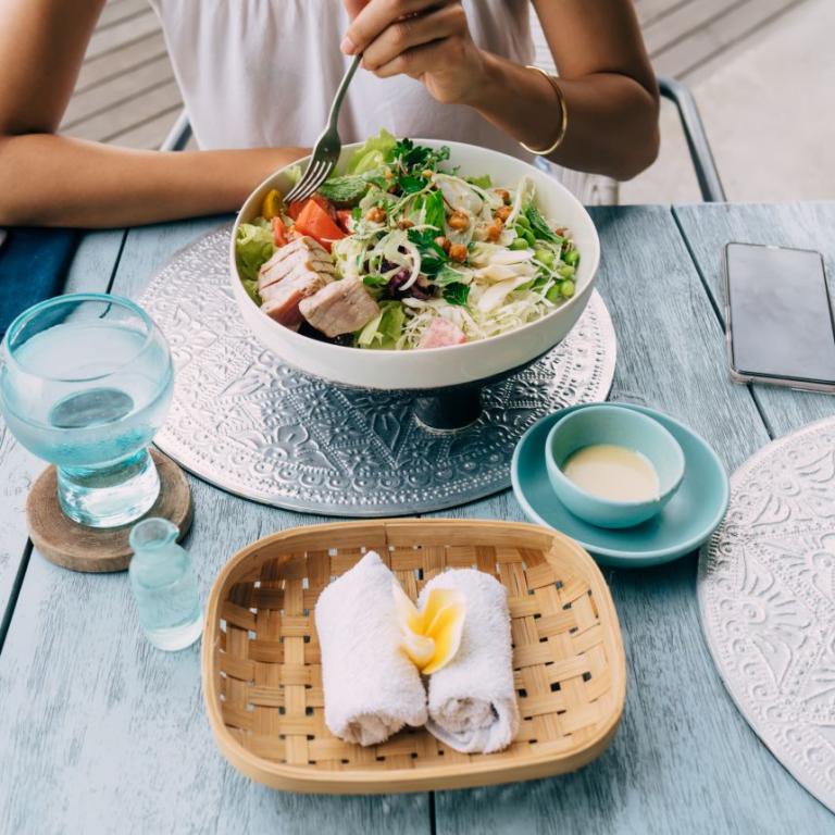 γυναίκα έχει νερό με το φαγητό στο τραπέζι