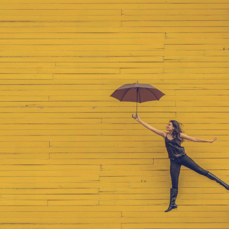 Γυναίκα που βρίσκεται στον αέρα και κρατάει μία ομπρέλα 