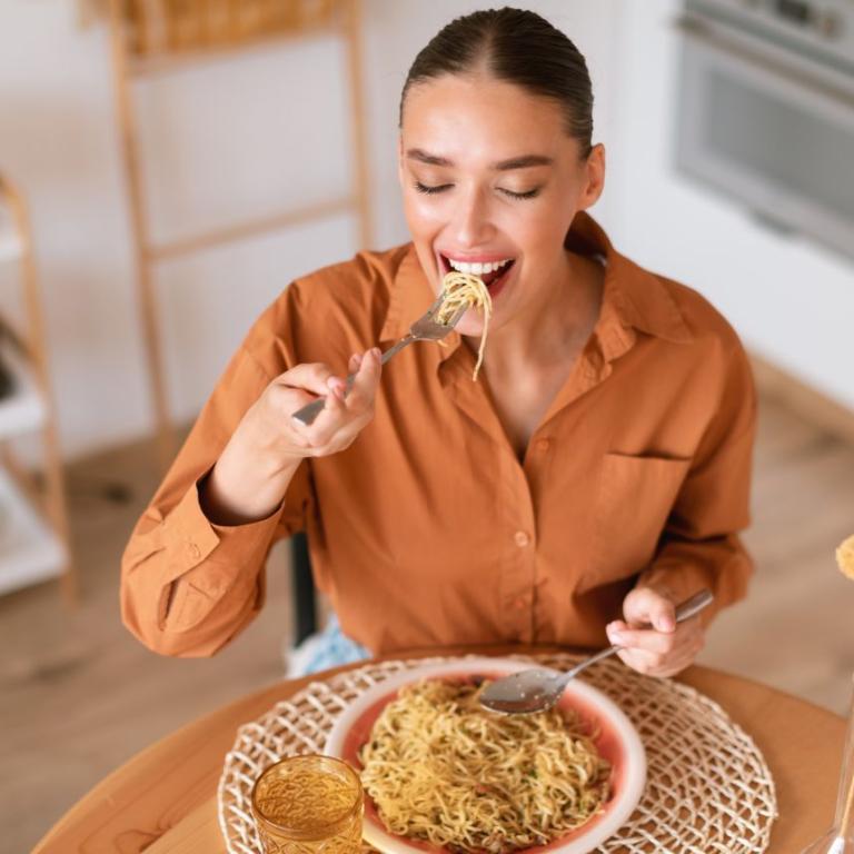 γυναίκα με αργό μεταβολισμό τρώει μακαρόνια