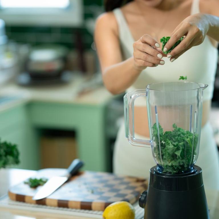 γυναίκα ετοιμάζει smoothie με kale για αδυνάτισμα και καλύτερο μεταβολισμό