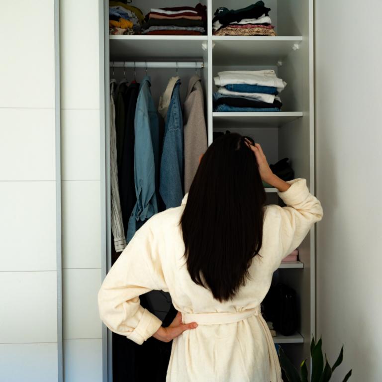 Γυναίκα που κάθεται μπροστά από την ντουλάπα της