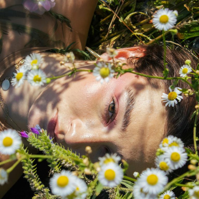 Κοπέλα περιτριγυρισμένη από λουλούδια 