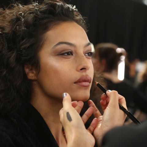 Μοντέλο που βάζει καφέ μολύβι στα χείλη της